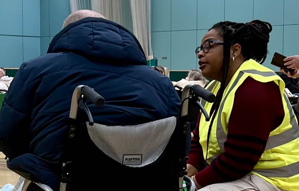 Staff in hi-vis talking to a visitor