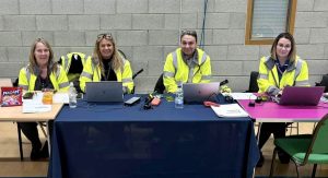Four women in hi-viz at desk