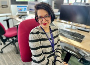 Woman wearing striped jumper sat at desk