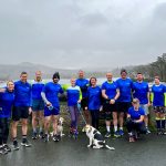 Team of runners wearing blue Livewell Southwest t-shirts by Burrator reservoir