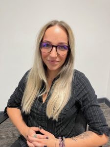 Woman with long blonde hair and glasses