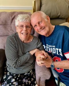Man and woman smiling, holding hands