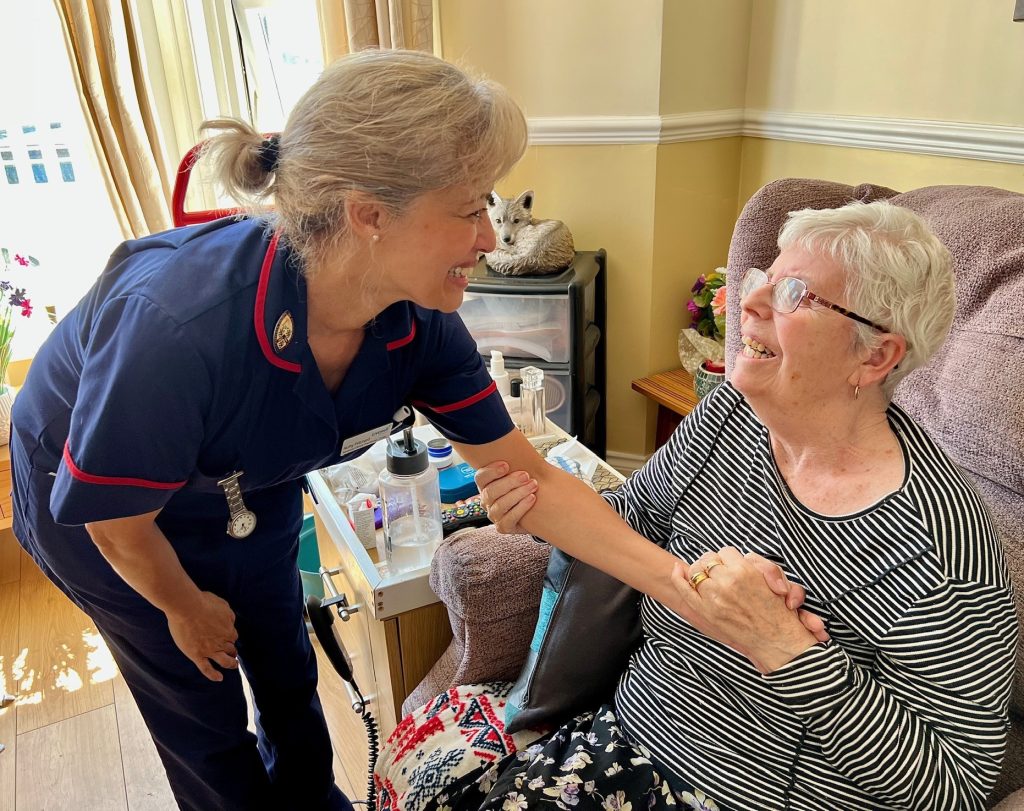 Nurse in blue uniform holding hands with woman