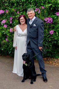 Bride and groom with black dog