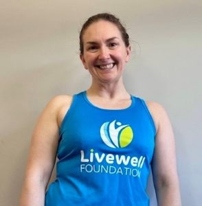 Woman wearing blue running vest with Livewell Foundation logo on it