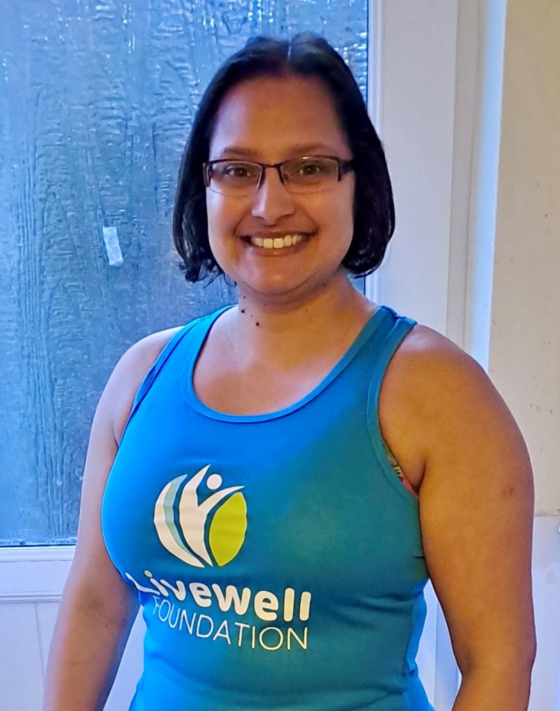 Woman in blue running vest with Livewell Foundation logo on it