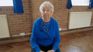 Woman with grey hair and blue cardigan