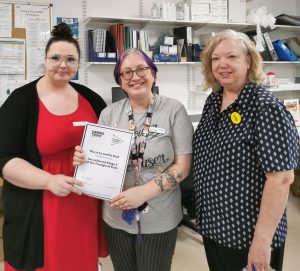 Three women holding a certificate