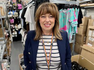 Woman smiling in clothing storeroom