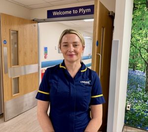 Woman with blonde hair in blue nurse uniform on ward