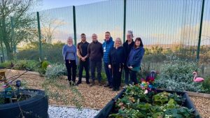 4 women and 3 men stood smiling in garden