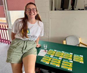 Women sat on information table smiling
