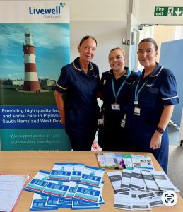 Three women in nurses' uniform stood behind an information desk