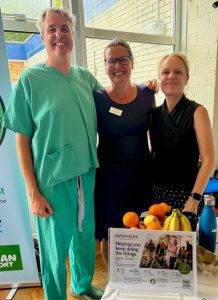 Man in doctor's scrubs with two women