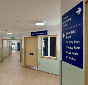 Reception area of new ward with signs saying welcome to the cove and directions to different rooms