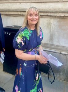 Woman with long blonde hair wearing blue floral dress