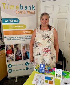 Woman in flowery dress stood by information stand