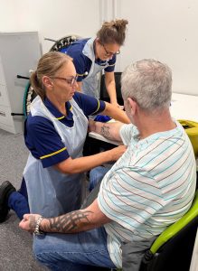 Man sat down with two nurses treating him