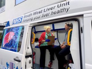 Two women sat inside the mobile NHS South West Liver Unit